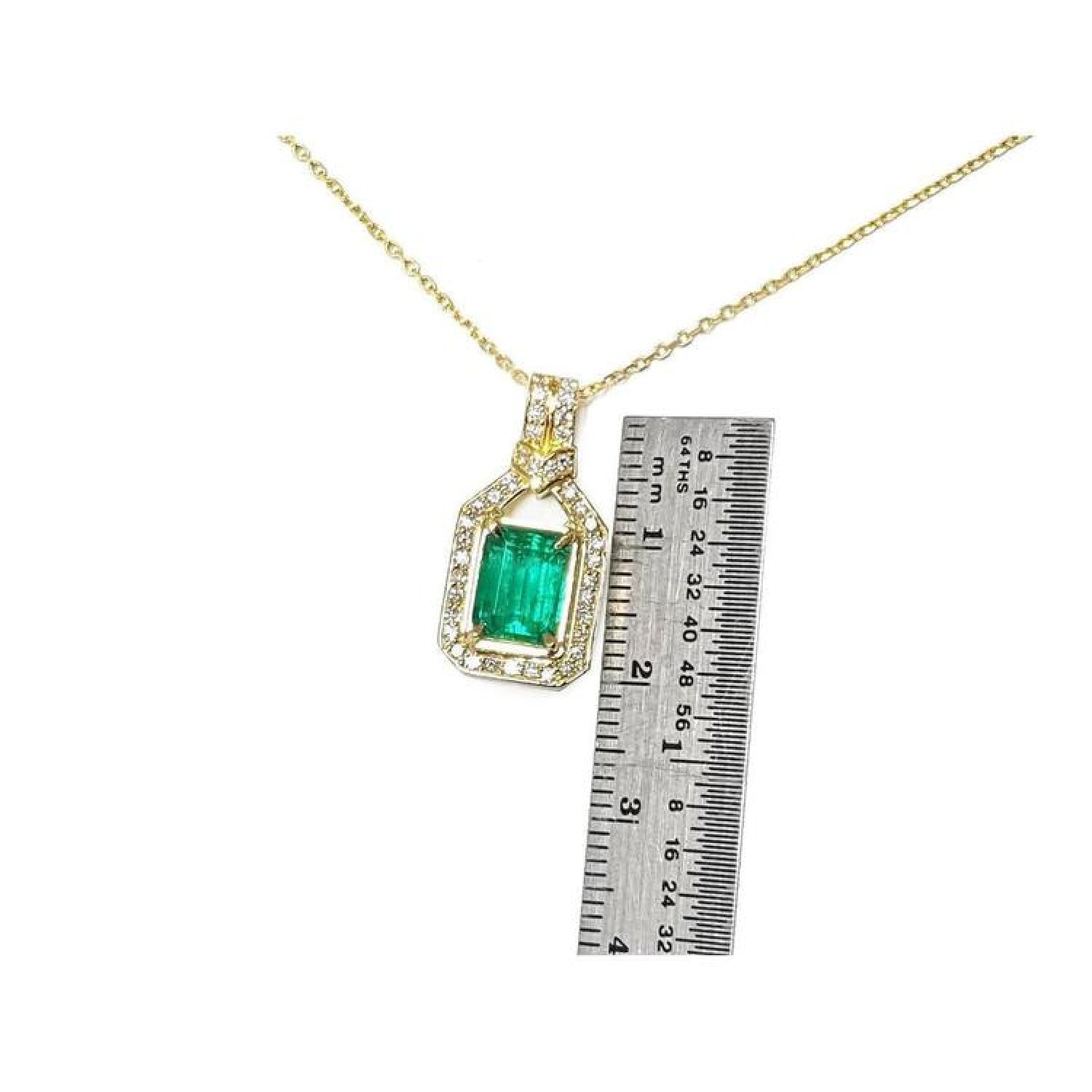 2.06 ct emerald pendant with natural diamonds in 18K yellow gold, shown with a ruler for size.