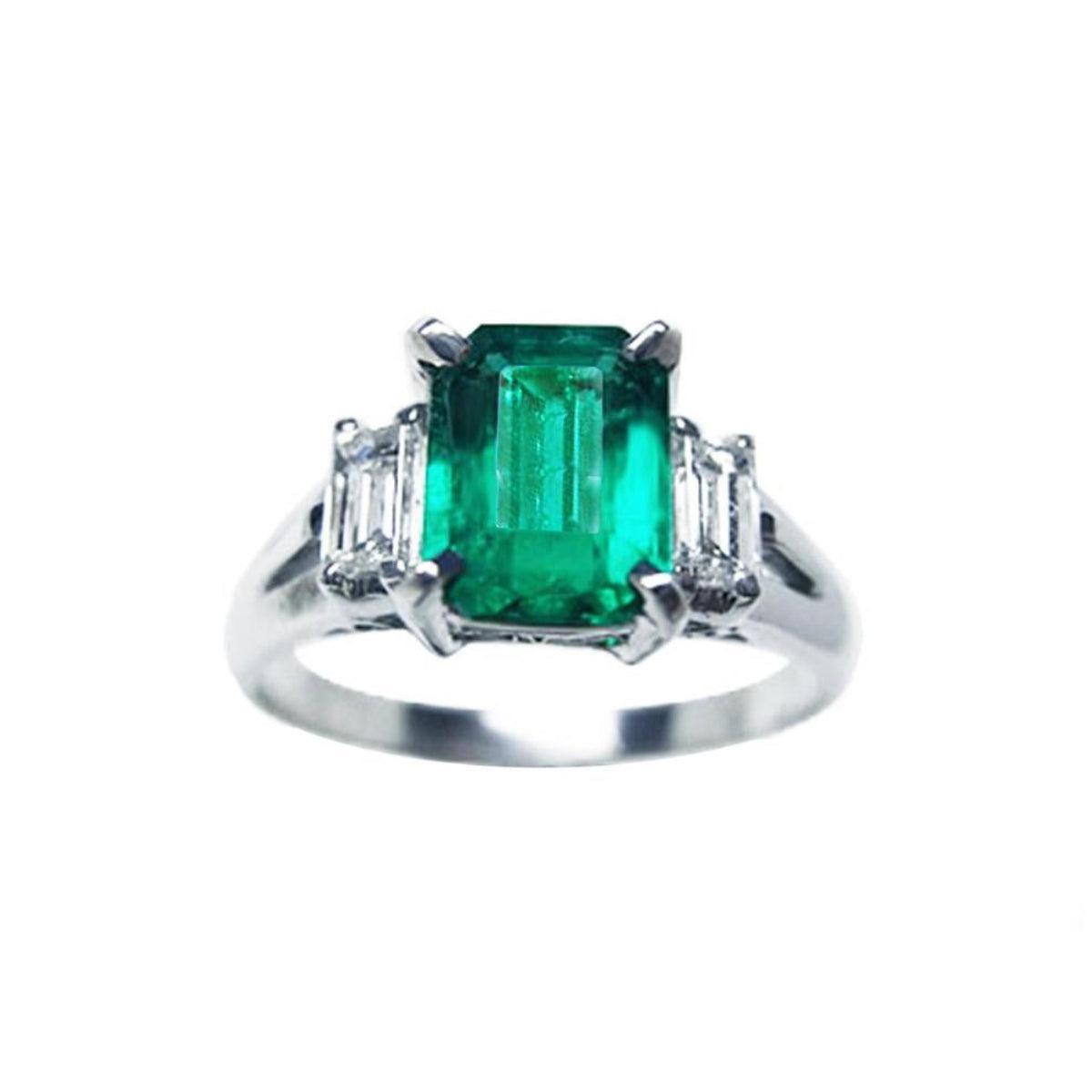 This three stone emerald platinum ring shows the topside with sides profile.