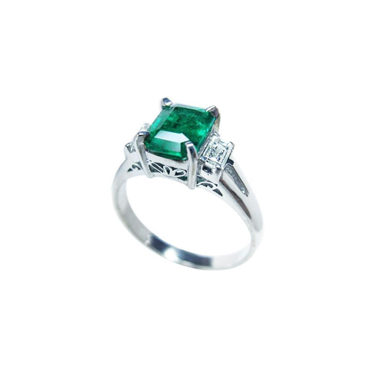 On a left side profile, a natural emerald three stone ring for women.