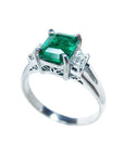 On a left side profile, a natural emerald three stone ring for women.