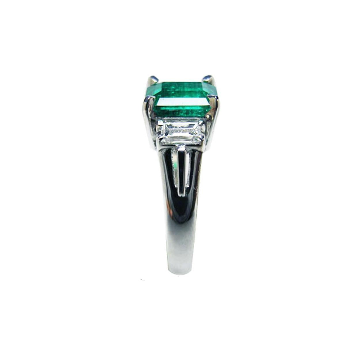 Platinum emerald ring on a side profile.