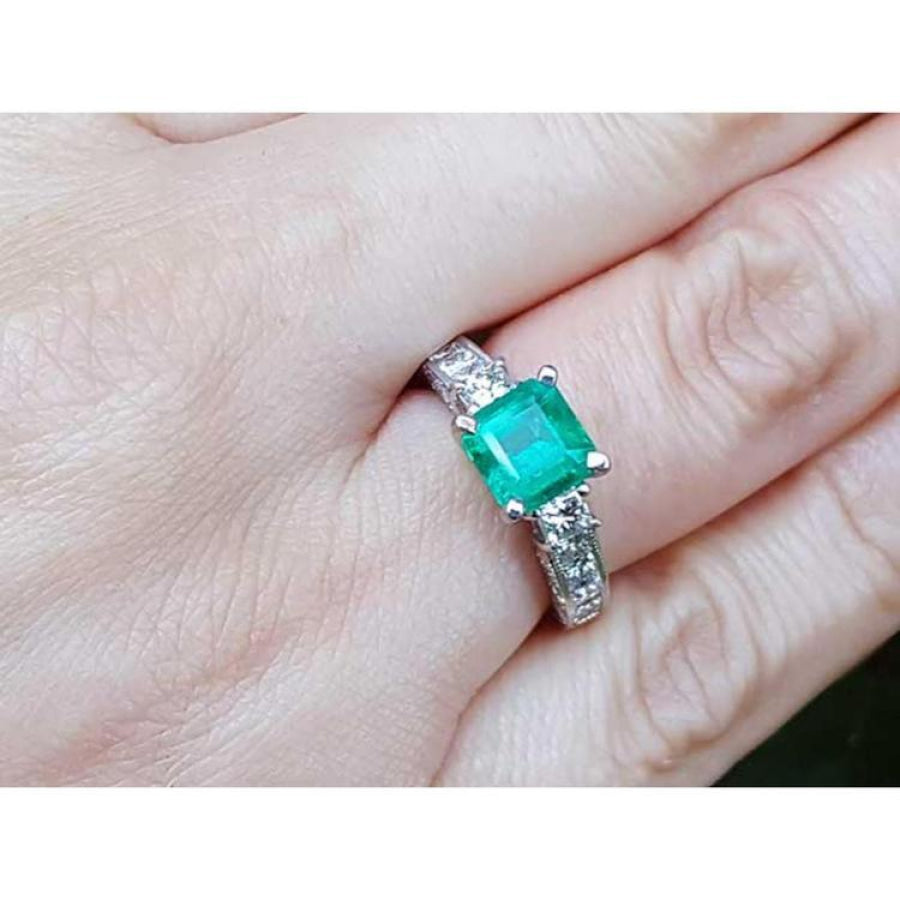 1.62 ct. square emerald ring with princess cut diamonds on a 14K white gold band.