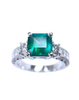 A real colombian emerald ring with side princess cut diamonds crafted in 14k white gold.