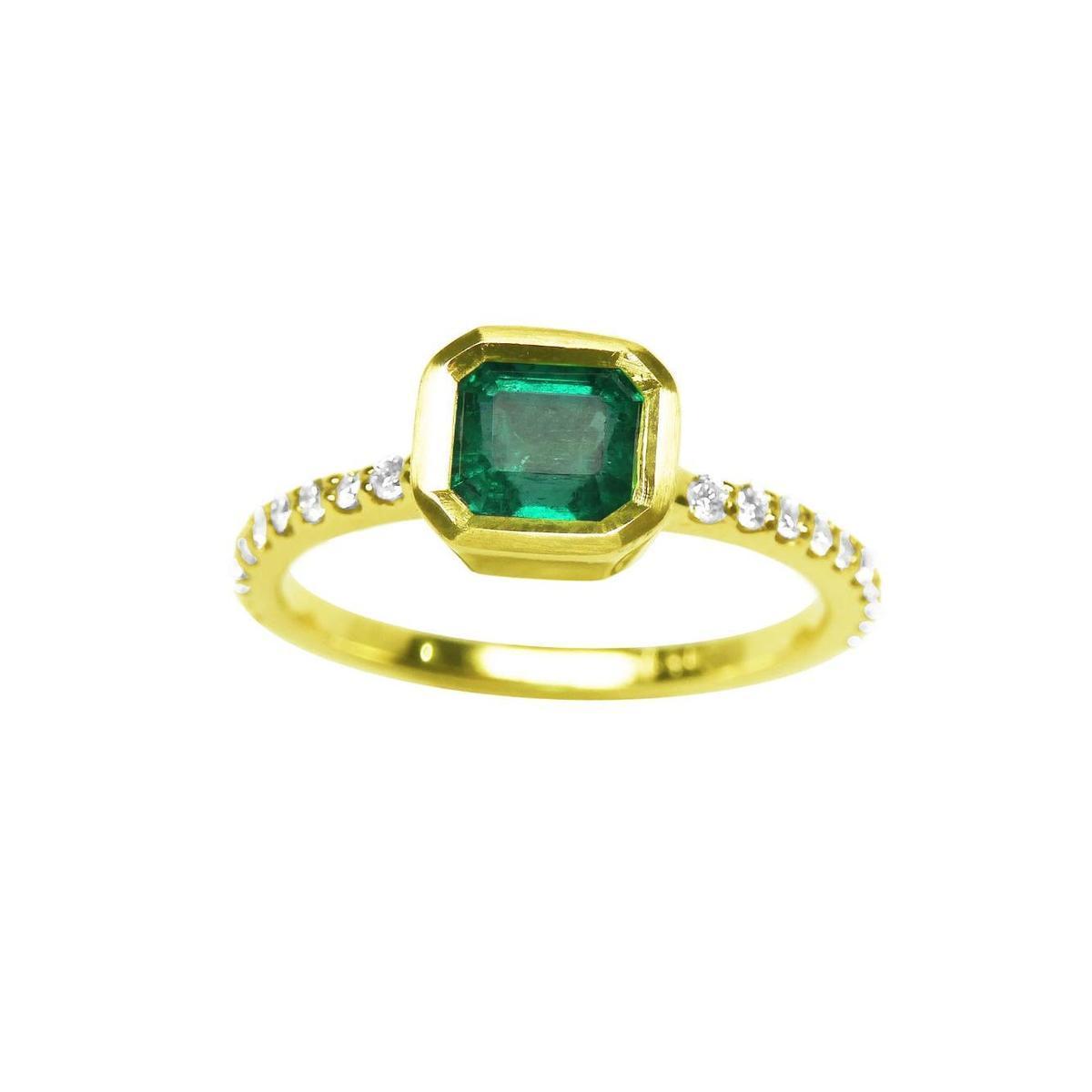 A topside view of a natural colombian emerald ring with diamond accents on a white background.