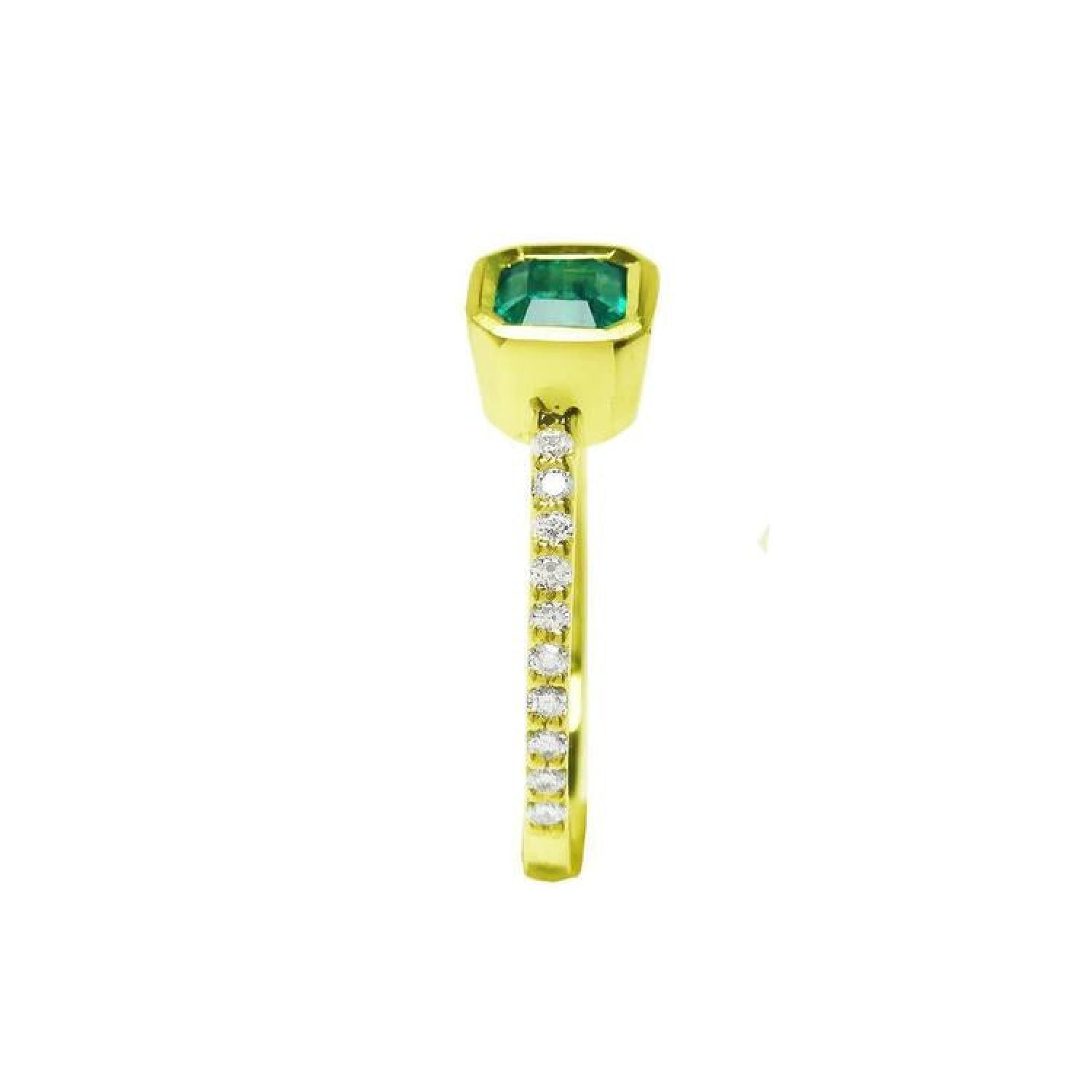 14K yellow gold emerald ring with a bezel-set emerald and accent diamonds on the band.