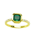 A natural colombian emerald ring with diamond accents made of 14k yellow gold.