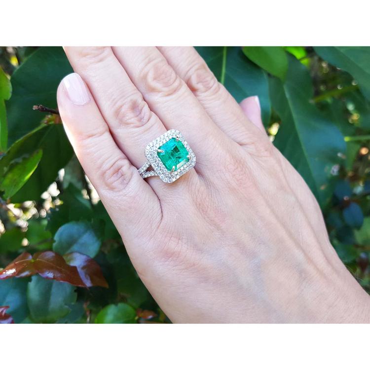 4.14 ct GIA-certified F1 Colombian emerald ring with diamonds in 14K white gold on a hand.