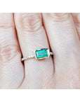 Emerald-cut bezel set natural colombian emerald ring in 14k yellow gold with accent diamonds.
