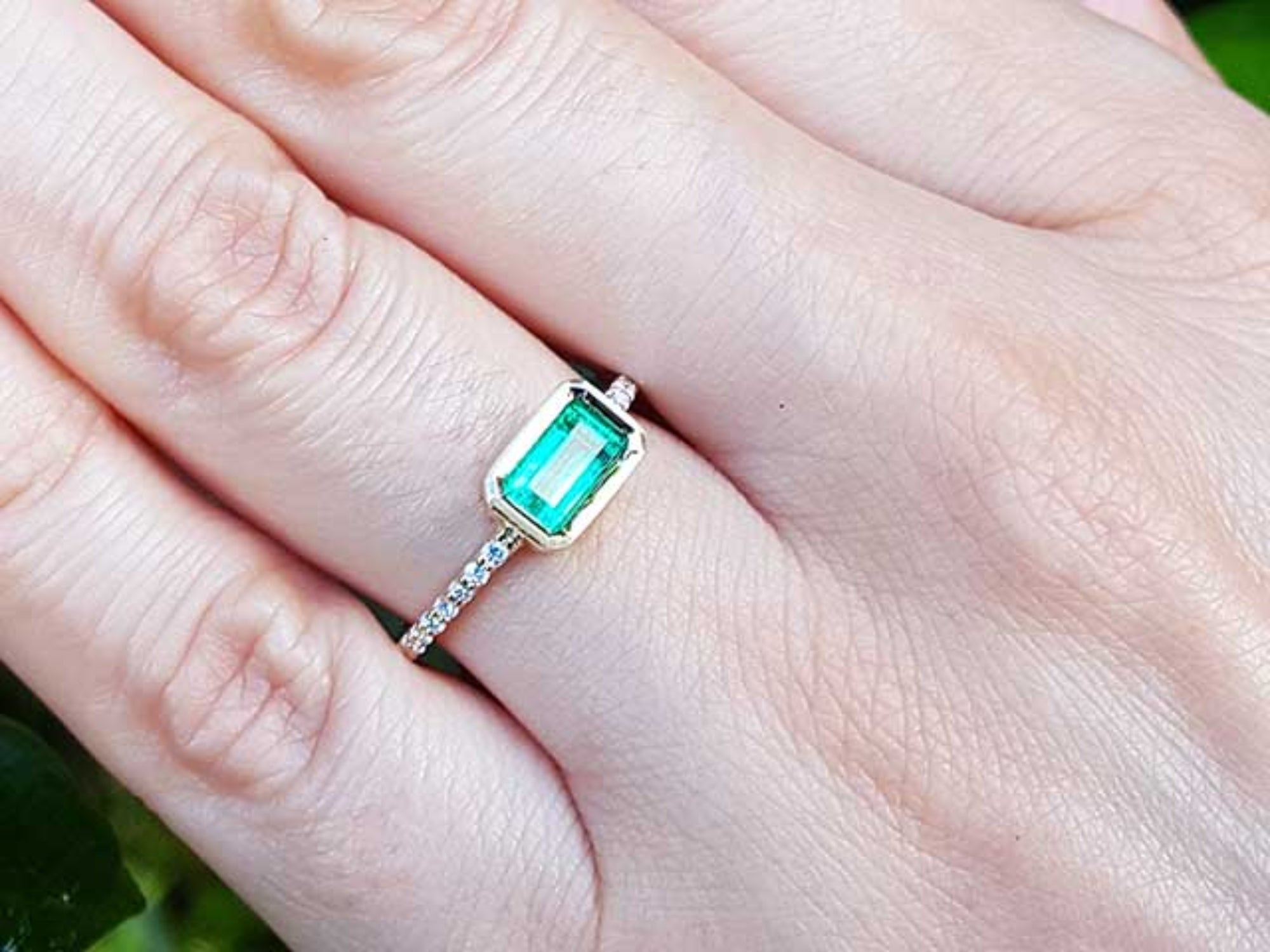 A real Colombian emerald ring on a finger.
