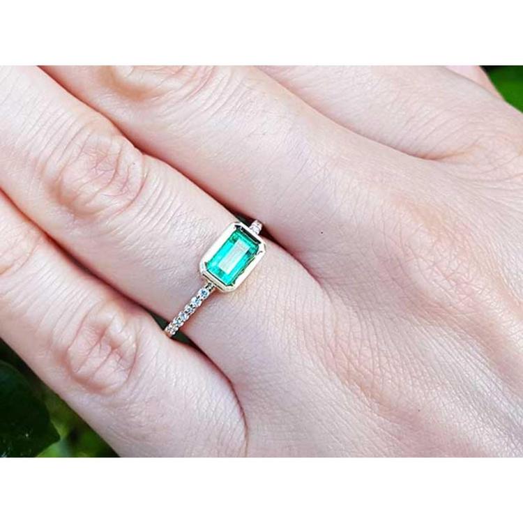 A real Colombian emerald ring on a finger.