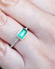A real Colombian emerald ring on a finger.