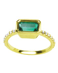 An east-west bezel set emerald ring in yellow gold with accent diamonds, is the perfect May's birthstone gift.