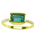 A yellow gold emerald ring bezel set with natural accent diamonds is the perfect gift as a May birthstone.