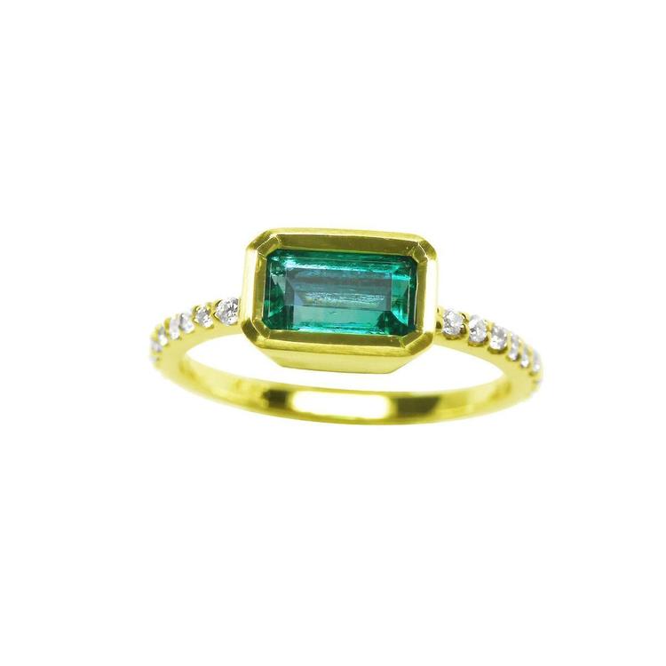 A yellow gold emerald ring bezel set with natural accent diamonds is the perfect gift as a May birthstone.