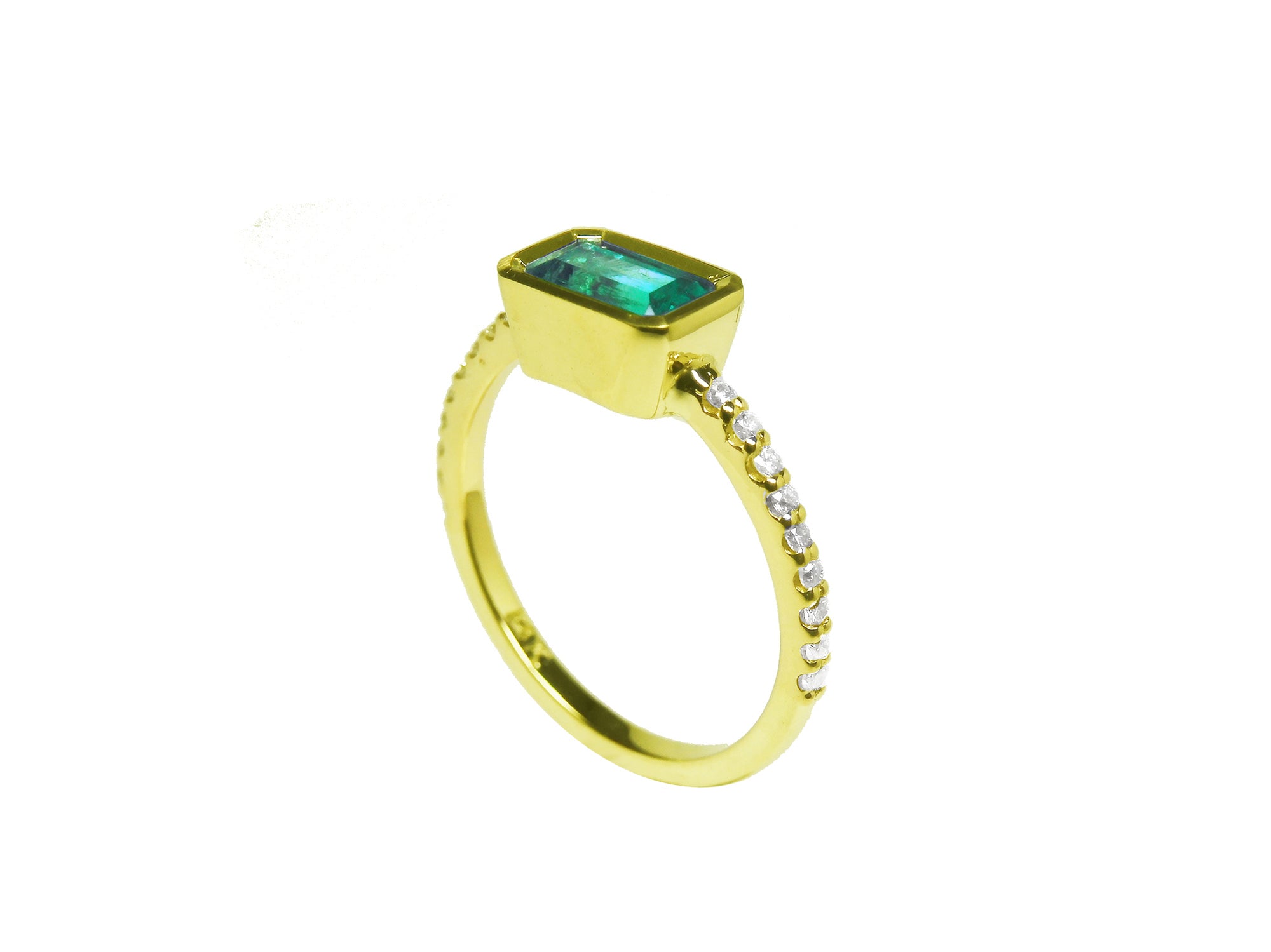 Side profile of a yellow gold emerald ring on a white background.
