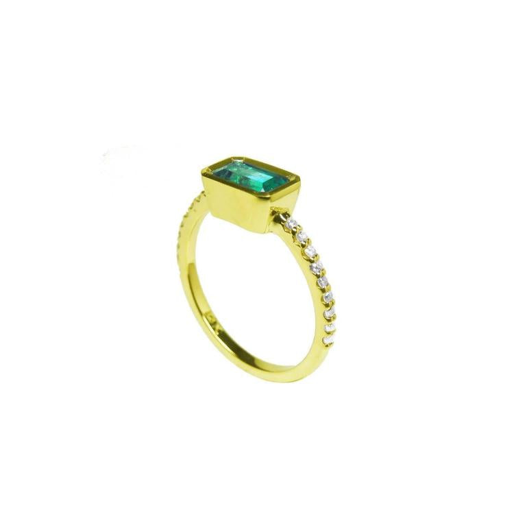 Side profile of a yellow gold emerald ring on a white background.