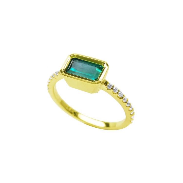 A yellow gold emerald bezel set ring, displaying the top and side diamonds accent along the band.