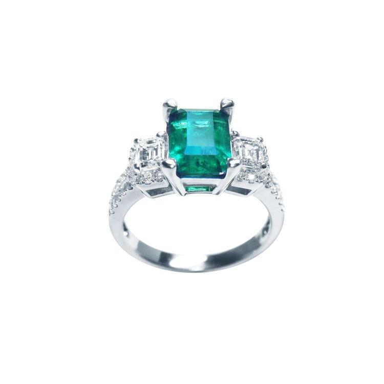 1.88 carat emerald ring with side emerald-cut diamonds and round accents in 18k white gold.