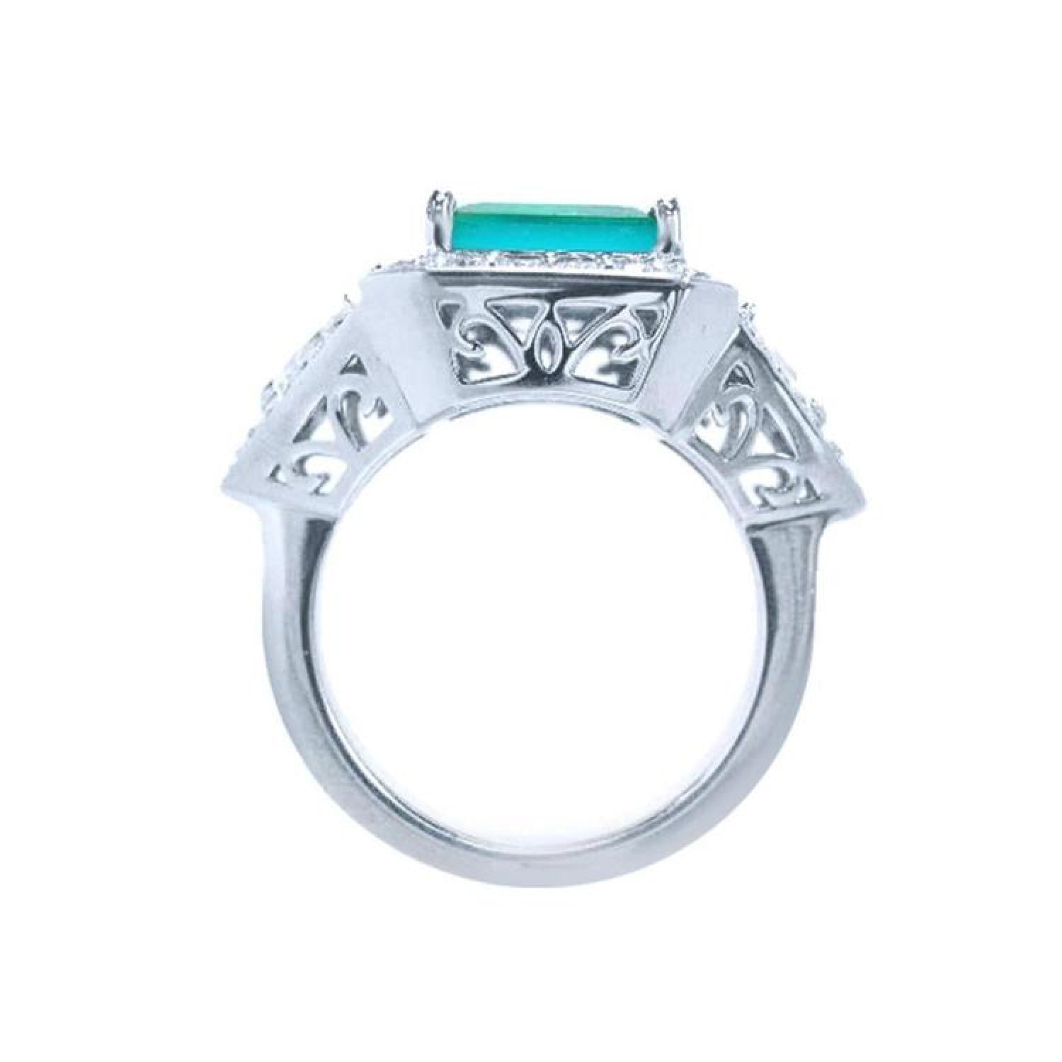 18K white gold ring with a rectangular emerald, diamond halo, and intricate filigree side details.