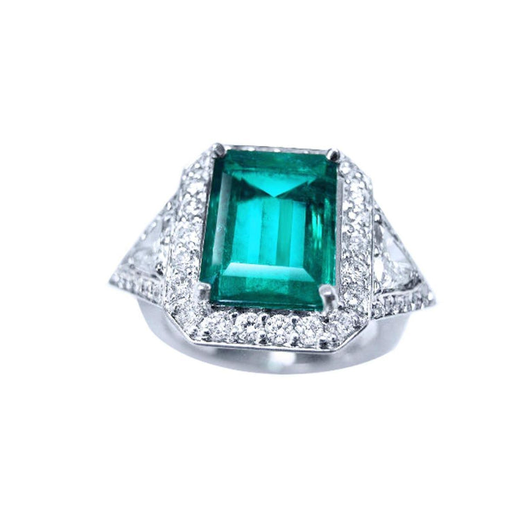 A natural colombian  emerald ring with side trillion genuine diamond GIA certified, made of 18k white gold.