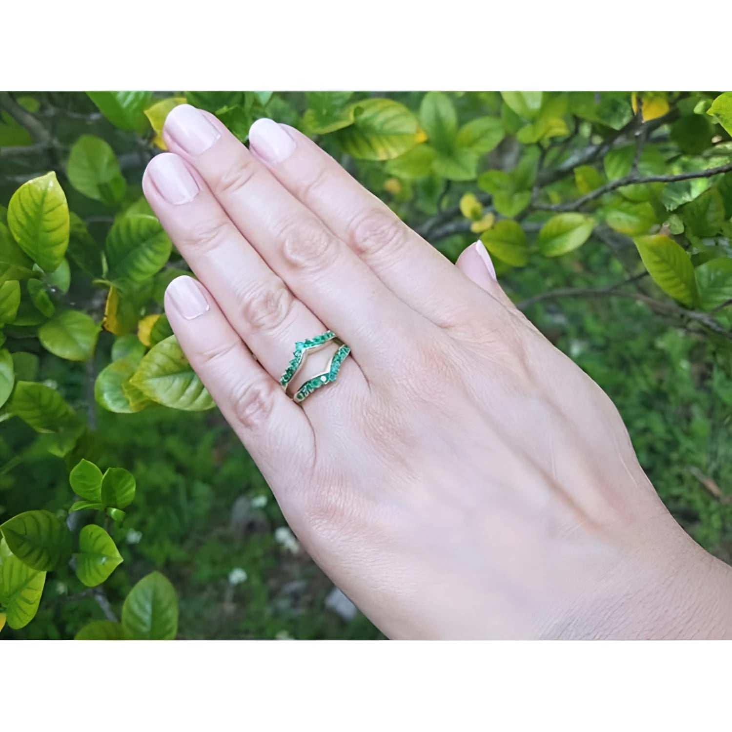 Hand wearing a 14K yellow gold emerald ring guard with 0.75 ct. round-cut Colombian emeralds.