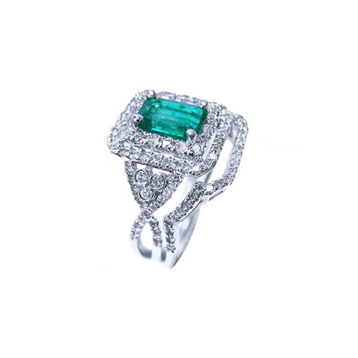 This Colombian emerald is into a double halo diamond on top of a white gold ring, side profile visibles.