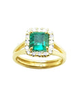 Halo diamond natural colombian emerald ring displayed with both sides profile in yellow gold.