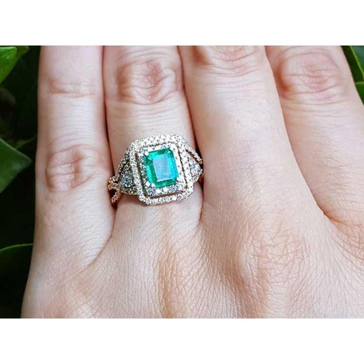 A bridal emerald engagement ring with double halo diamonds in 14k yellow gold.