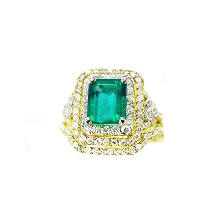 This Colombian emerald ring with matching band has a double halo of diamonds and it was crafted in 14k yellow gold.