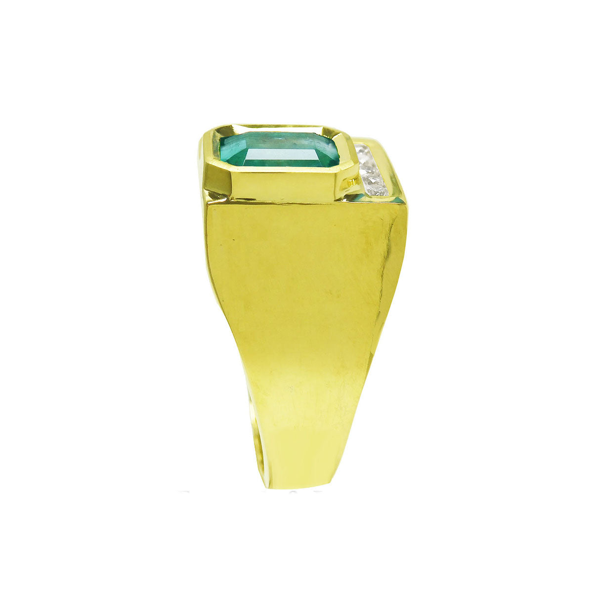 Gold ring with a bezel set natural emerald on a side position displaying top and side profile band design.