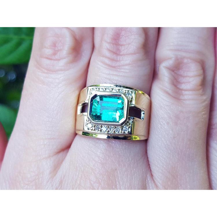A natural colombian emerald mens ring on a person's finger.