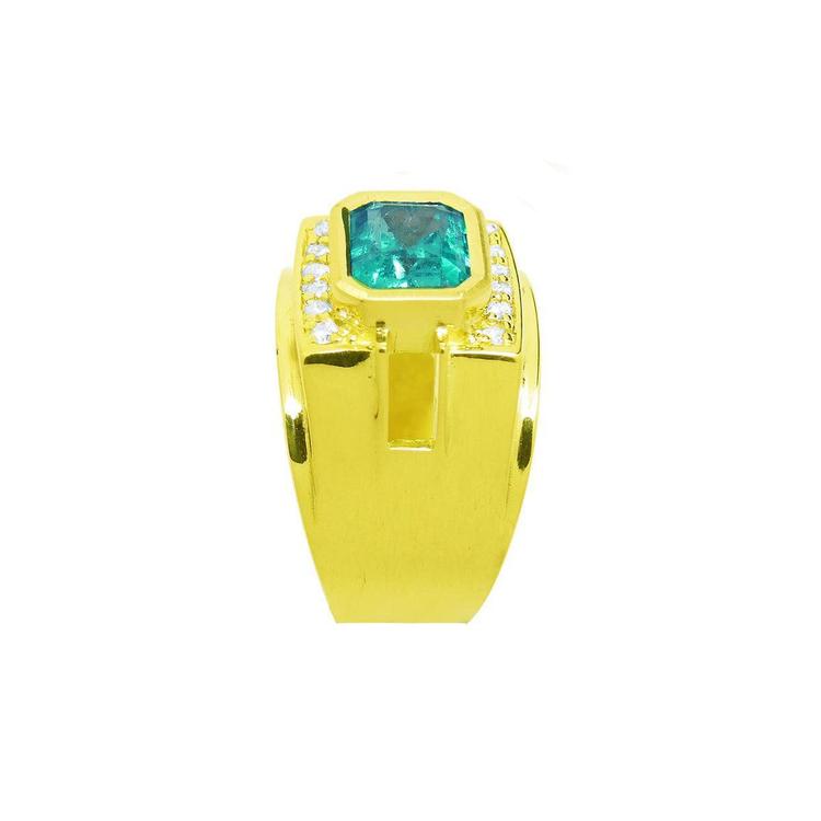 A clear display of this yellow gold emerald ring for men showing the top and side band profile.