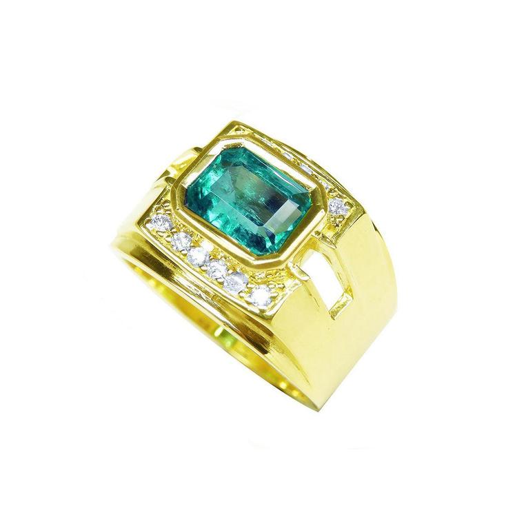Gold ring with a bezel set natural emerald and small diamonds on a topside view profile.