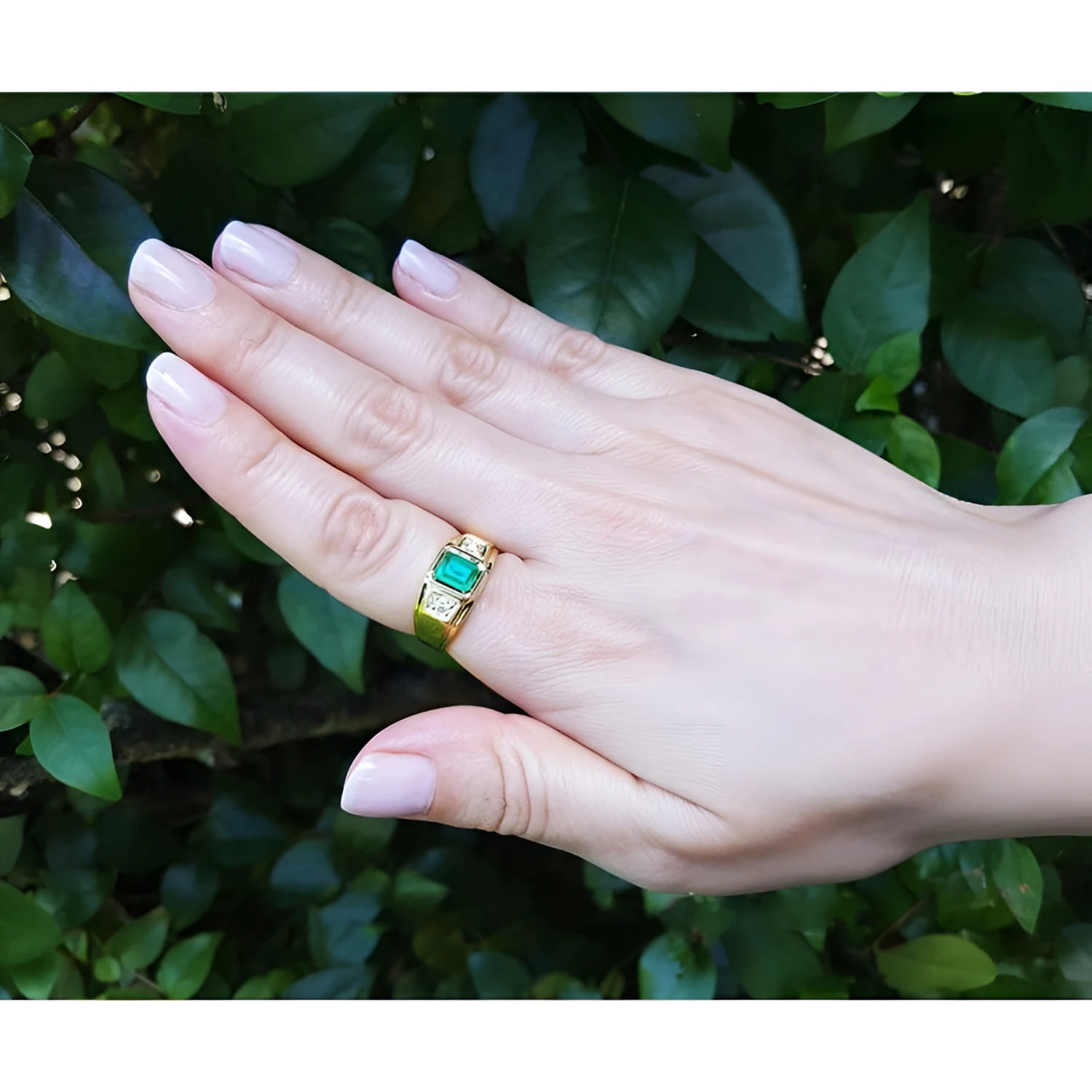 Men's 18K yellow gold ring with a bezel-set Colombian emerald and two prong-set side diamonds.