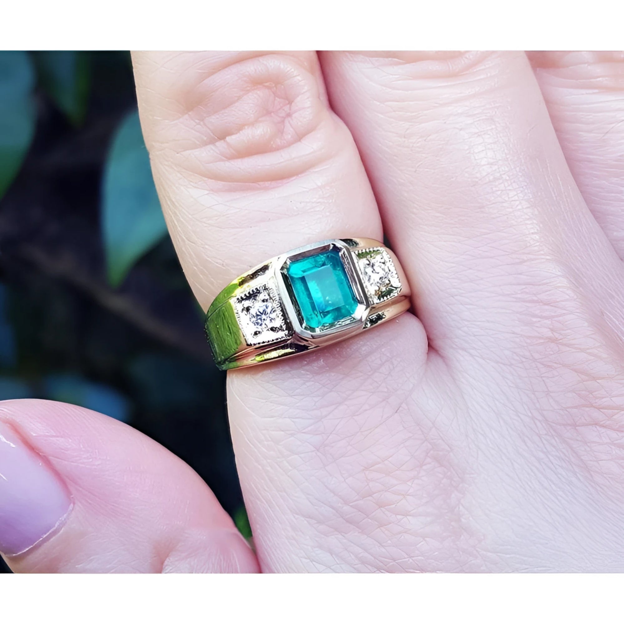 18k yellow gold ring for man with a natural colombian emerald and accent diamonds worn on a finger.