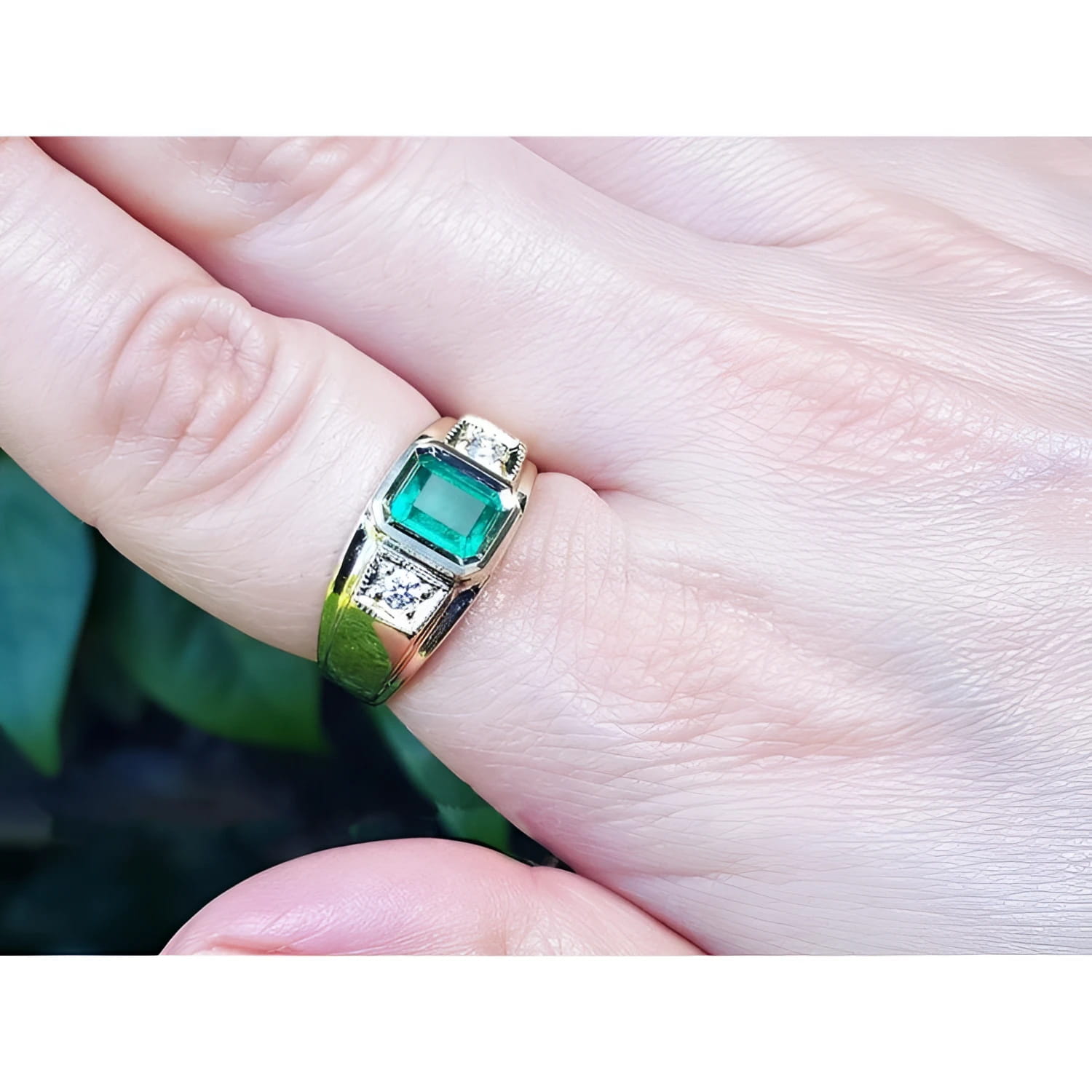 18K yellow gold men's ring with a bezel-set rectangular Colombian emerald and two side diamonds.