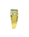 A side profile of a yellow gold men's emerald ring, top setting and side band design view.