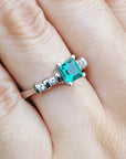 Ring with a Colombian emerald on a person's finger.