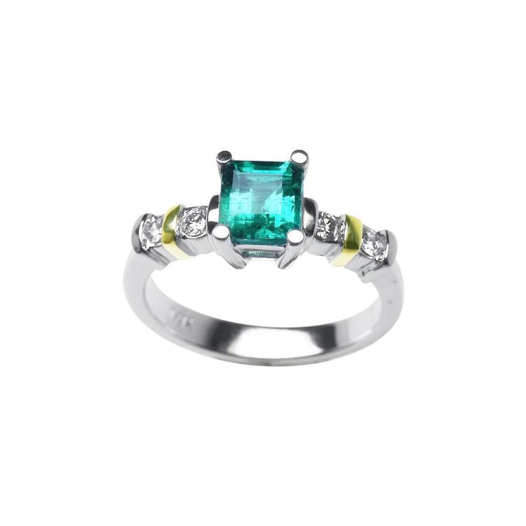 14K white gold ring with a square emerald cut Colombian emerald and side diamonds, accented with yellow gold.