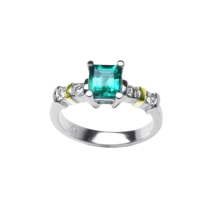 14K white gold ring with a square emerald cut Colombian emerald and side diamonds, accented with yellow gold.