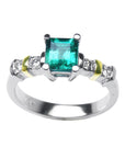 White gold emerald with accent diamonds ring on a white background.