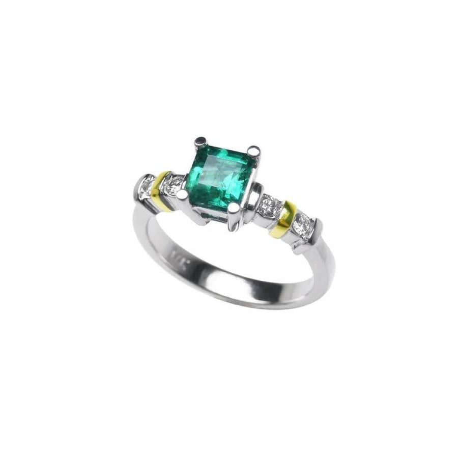 14K white gold ring with a square emerald cut Colombian emerald and side diamonds, accented with gold bands.
