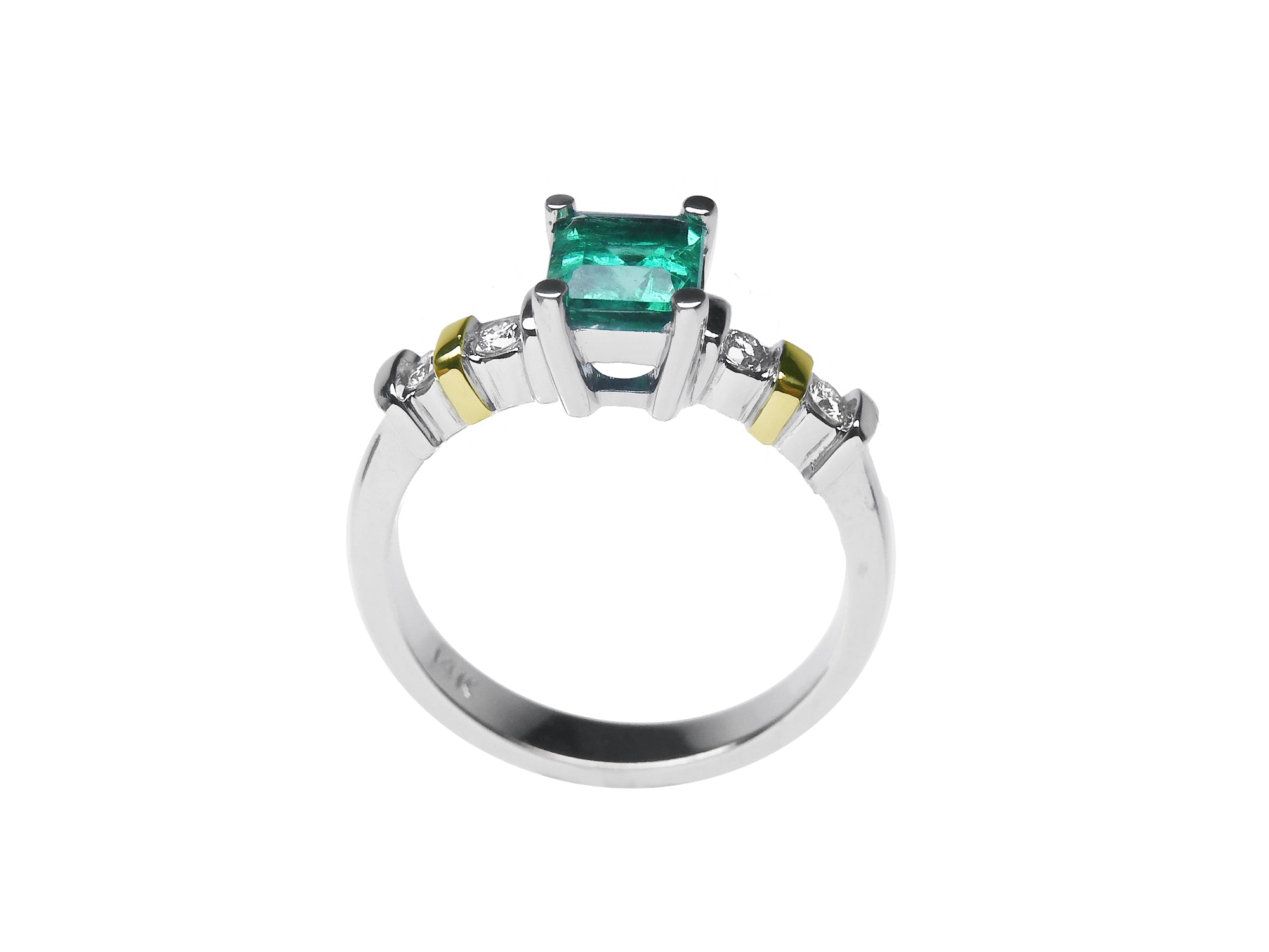White gold emerald and accent diamonds ring lateral profile.