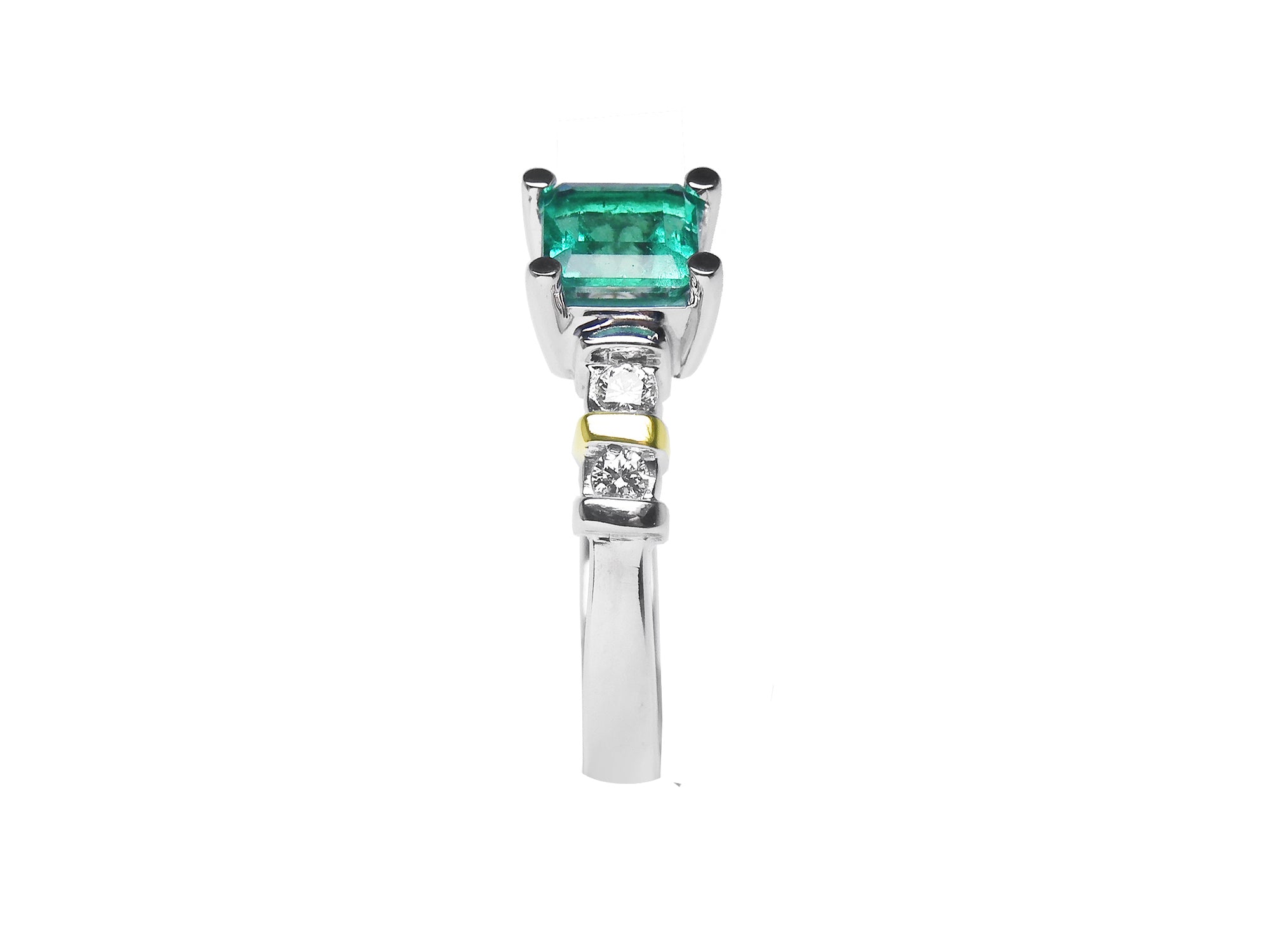 Side profile of a square emerald and round diamonds on the band of the ring.
