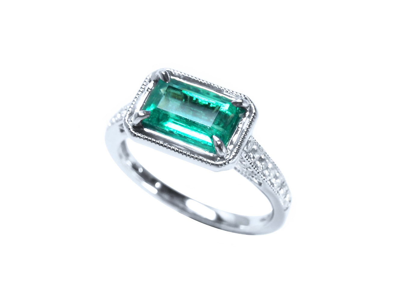 Ring with a natural colombian emerald and diamond accents on a white background