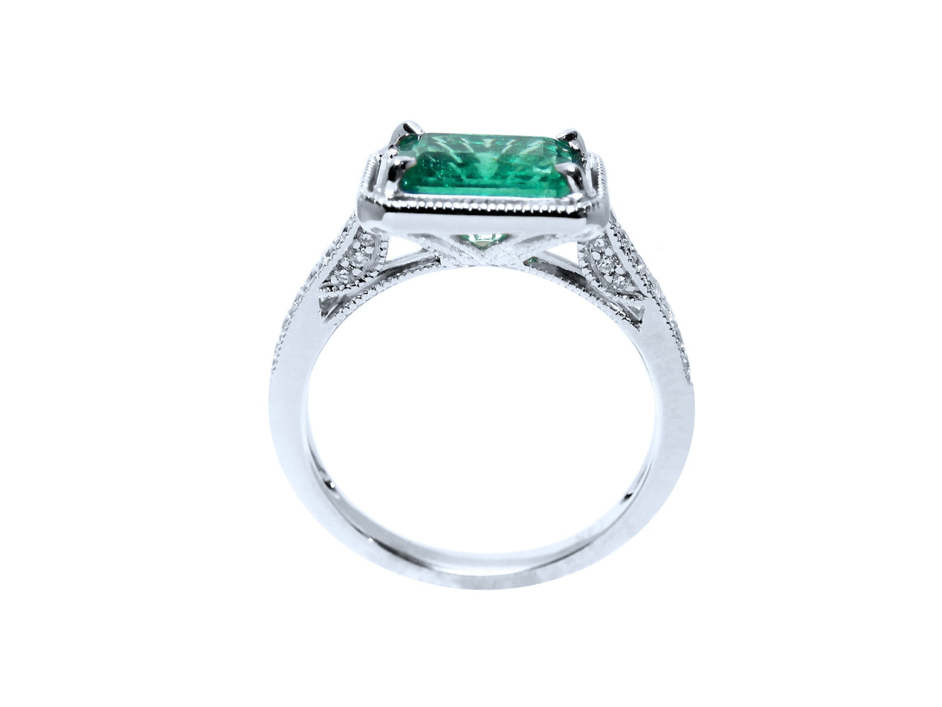 The lateral view of this natural emerald and diamond ring displays its lateral top setting and gallery design.