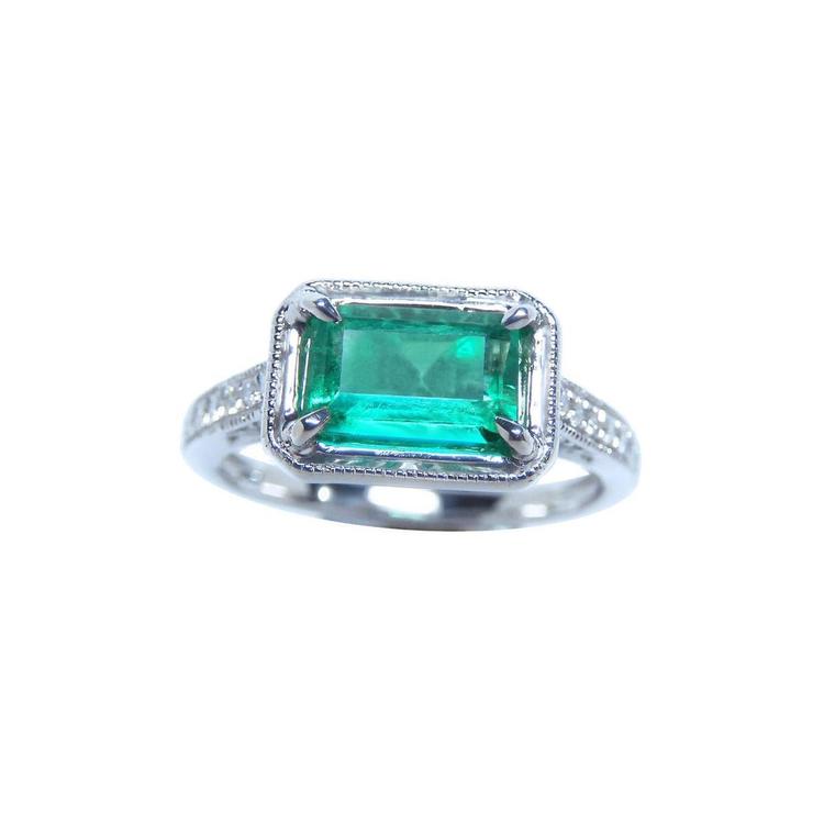 Natural emerald and diamond ring prong set and side diamonds of the band design.