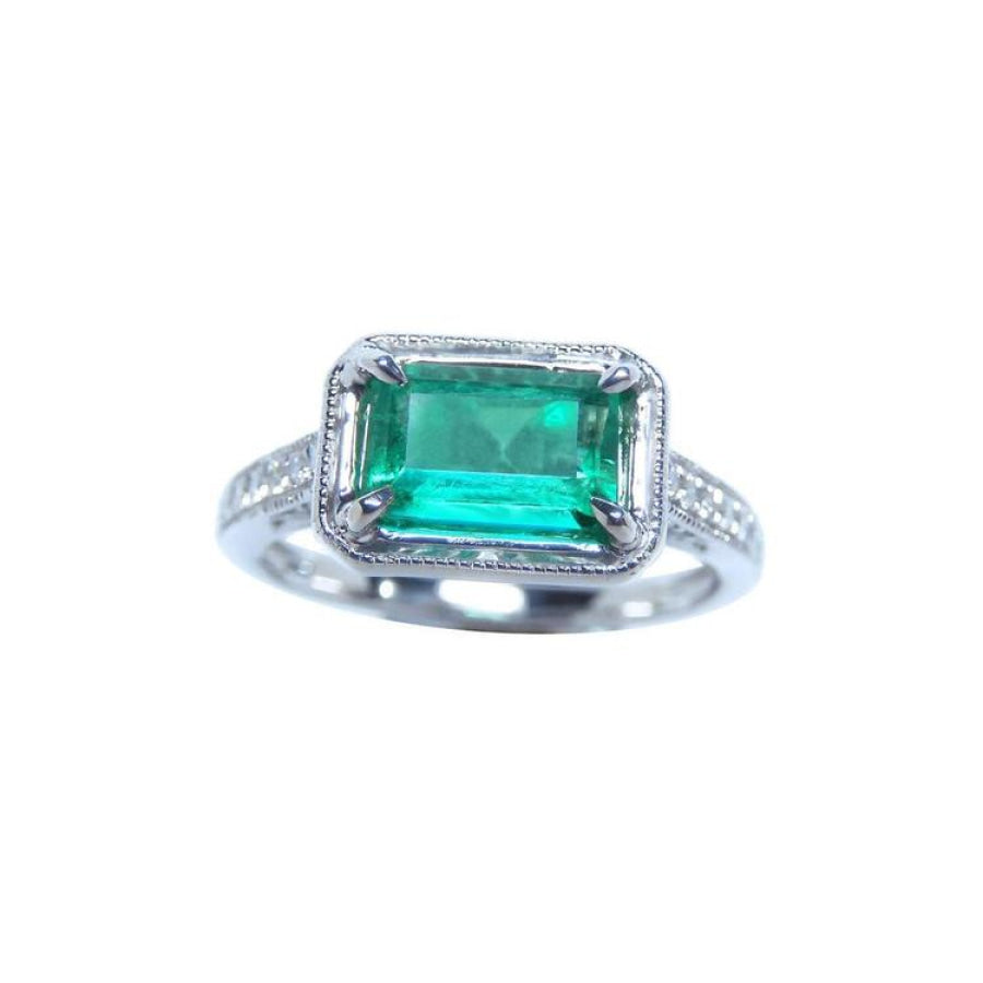 Natural emerald and diamond ring prong set and side diamonds of the band design.