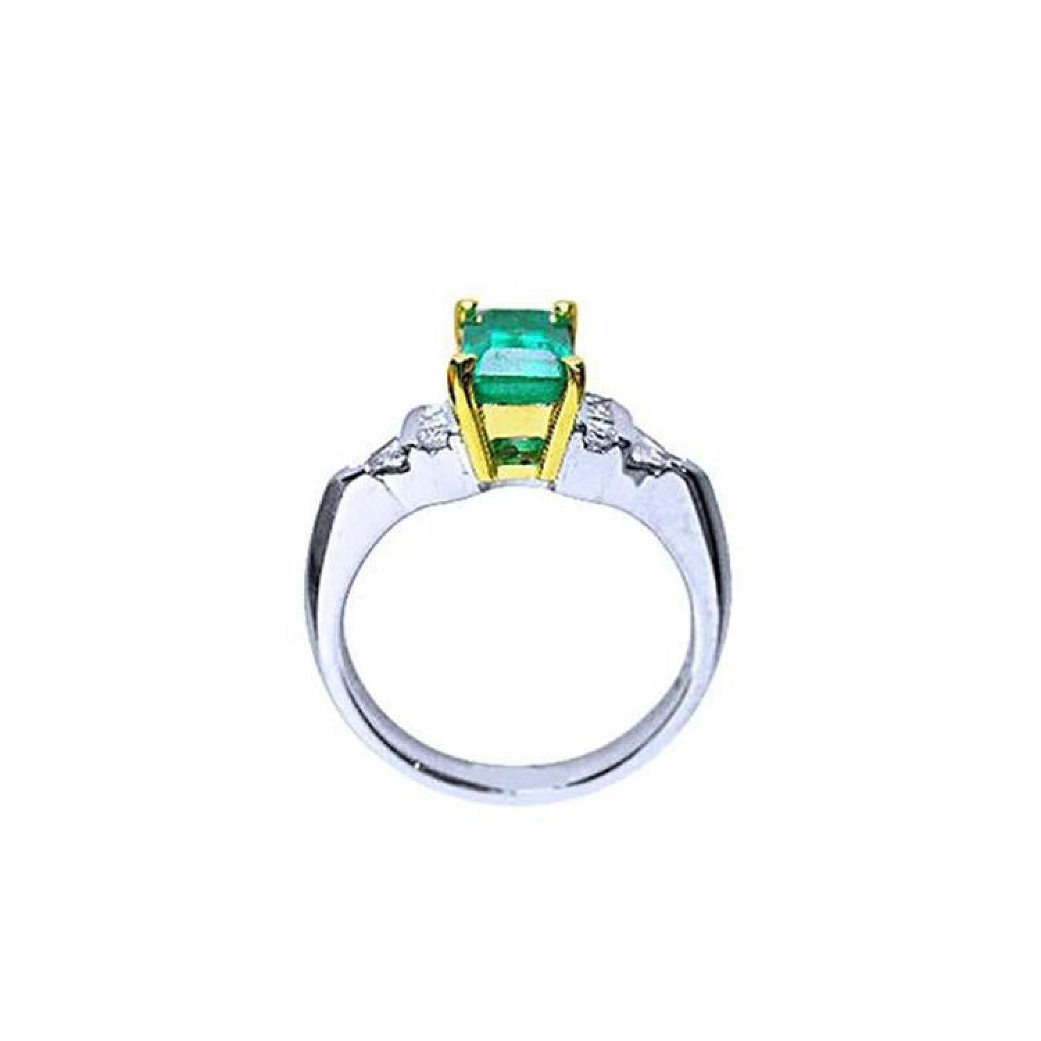 Platinum ring with 1.21 ct emerald in 18K yellow gold setting, flanked by diamond accents.