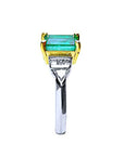 A side profile of a platinum emerald ring and accents on a white background.
